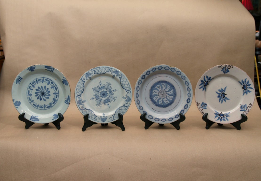 Four English (Bristol, Liverpool and London) Delft plates, The first with pinwheel decoration, the second with foliate and diaper border, the third with strung bead boarder, the last with overall foliate design.