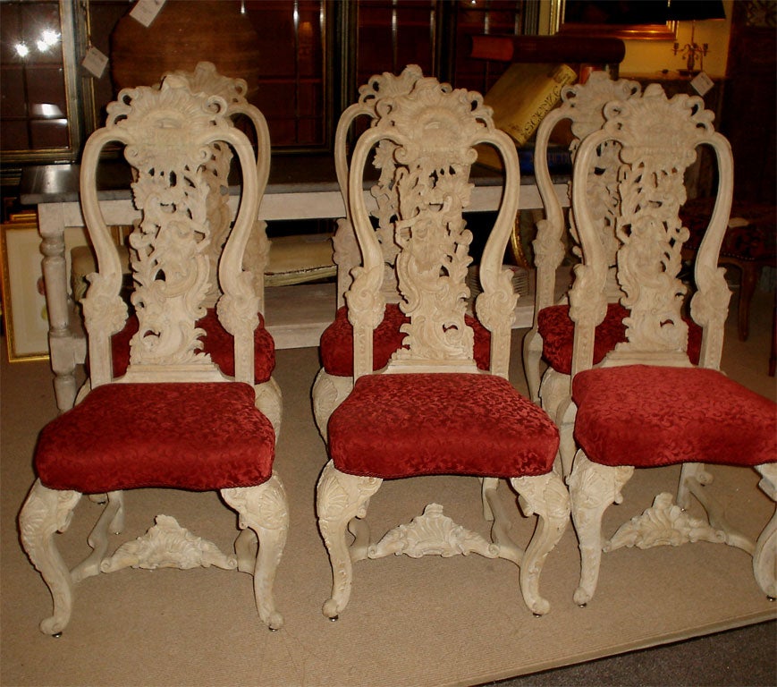 

6 [Six] Fabulous carved wood chairs.  Three with the pattern running to the left and three running to the right with upholstered bottoms.  Each shell carved top rail above pierced foliate carved splats.  The upholstered seats on shell carved