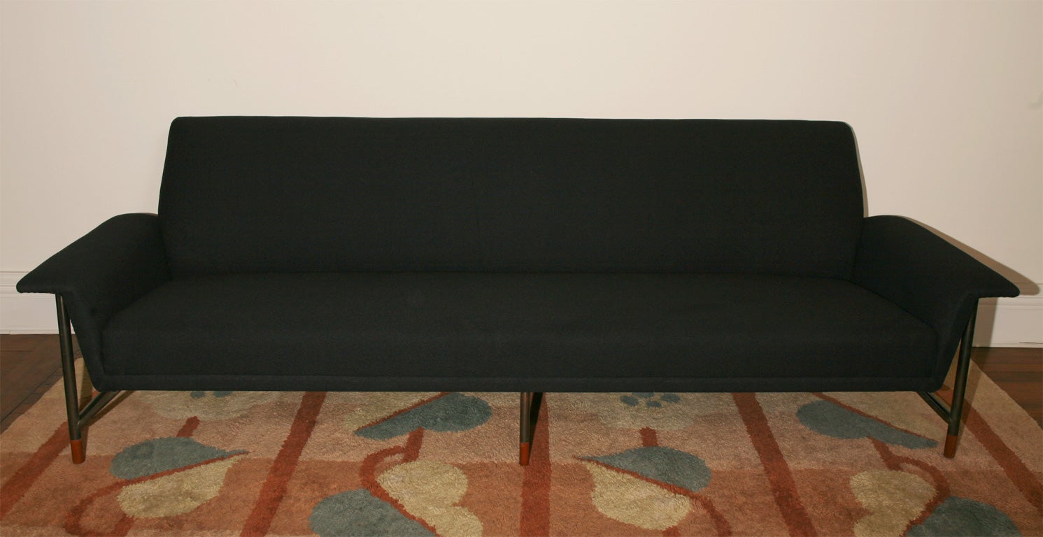 Long sofa designed by F. Juhl.<br />
Mnufactured by: Bovirke.<br />
Lacquered tubular steel with walnut wood feet and black wool.