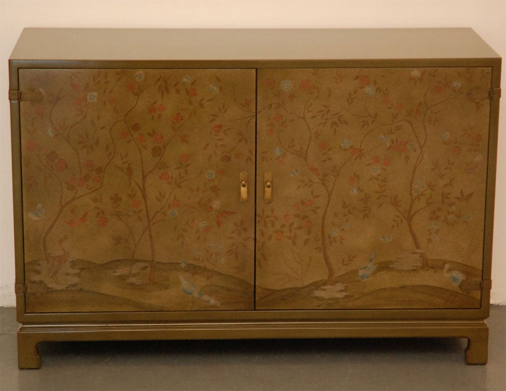 Gorgeous chinoiserie cabinet by John Widdicomb stained in deep olive with scenic trees painted on front cabinet doors.  Inside is open shelving with 2 pull out drawers.  Perfect for under flat screen television.