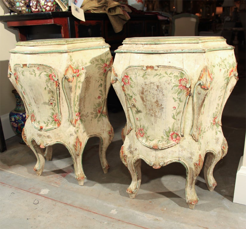 Charming pair of painted cabinets with bombe shape and lots of character.  Apple green accents with red & yellow.  Off white crackled base color.  Interiors are lined with a tuscan gold colored fabric.