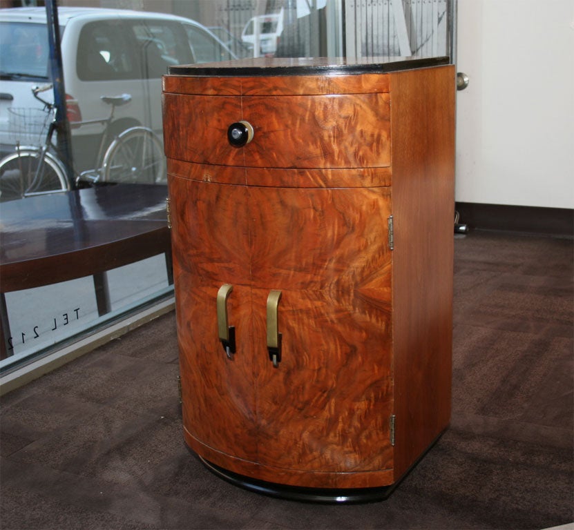 This stunning end table features book-matched walnut with pulls made of nickel, bronze, and bakelite. It is with a single drawer as well as a cabinet containing interior shelving perfect for storing everything from bedside reading to objets d'art.