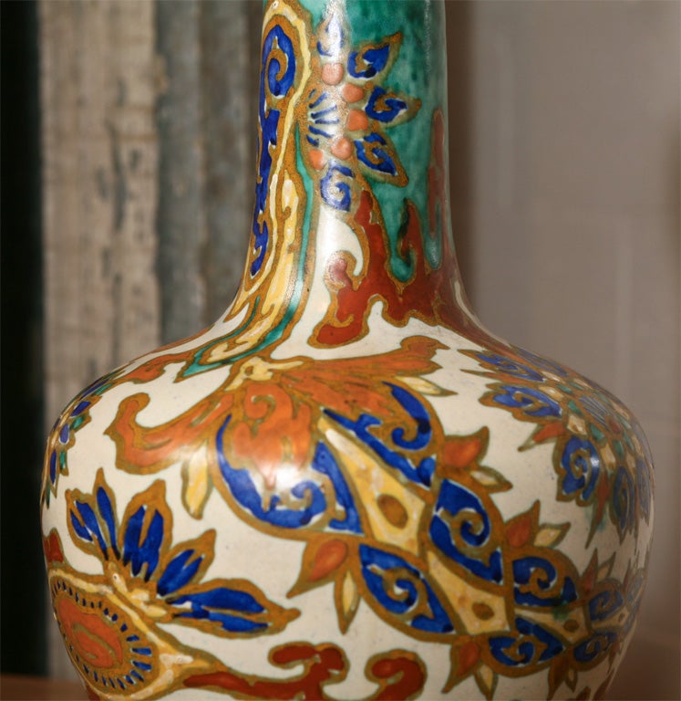 Gouda pottery lamp with Moroccan inspired design.<br />
Floral and paisley motif. Original hardware.<br />
Attached harp and finial.