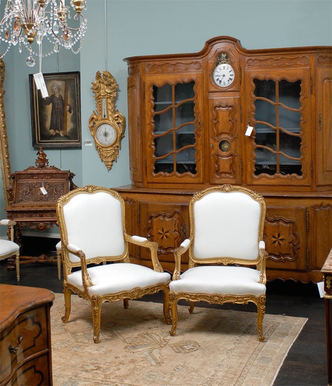Paire de fauteuils de transition Louis XV/XVI du 19ème siècle dorés à la feuille