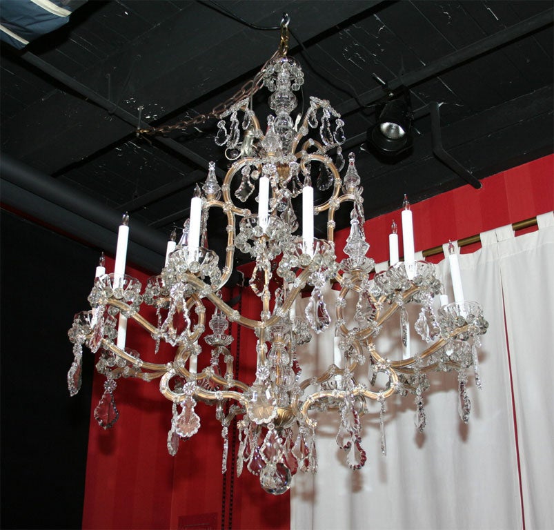 Gilt iron chandelier with glass panels covering the sides of the frame.  The bobeches are trimmed with faceted crystal balls and the chandelier is trimmed with cut crystal pendalogues.