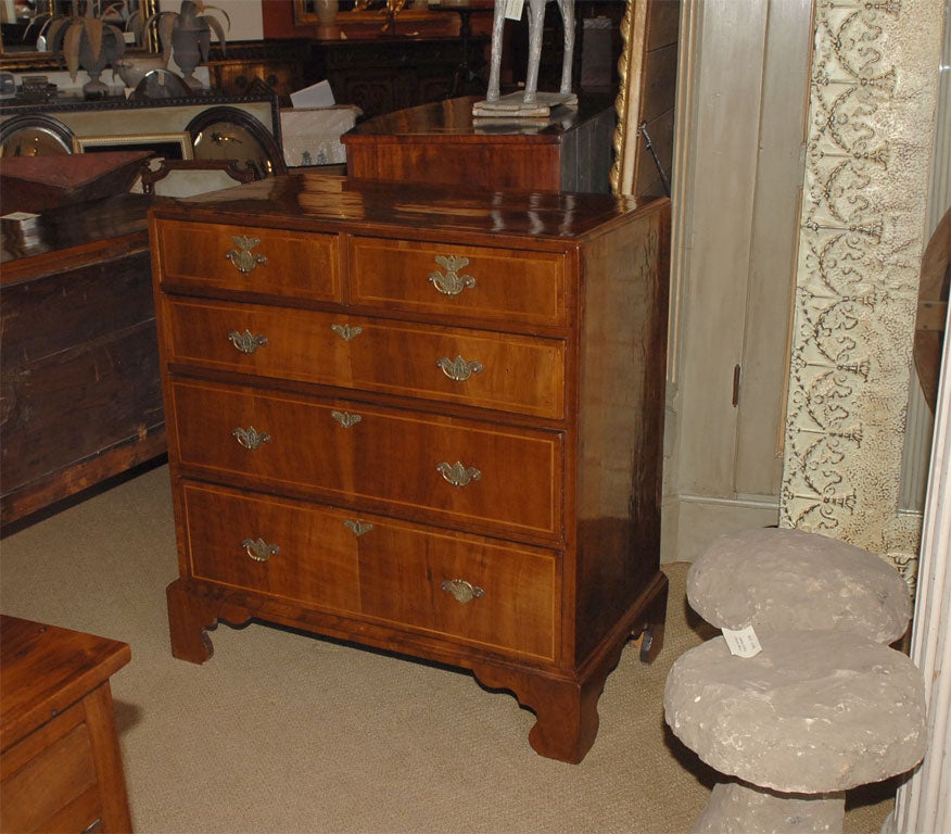 An 18th century English caddy topped walnut chest of drawers with satinwood inlay, circa 1780.