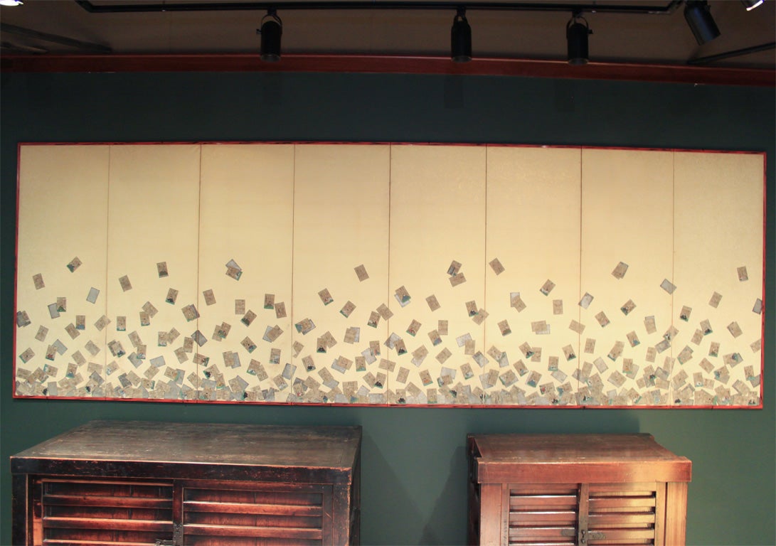 Unusual eight panel folding screen (byobu) with scattered playing cards.  The cards fall from the top of the screen gathering at the base of the screen. The cards are uta karuta (