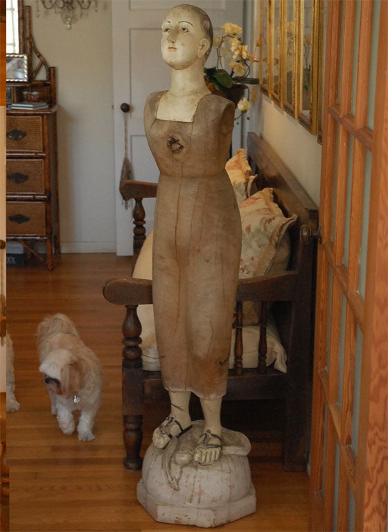 This is a great old life size santos, all carved out of wood, with a detailed painted face and glass eyes. The head comes off, so it can be mounted seperately, and the face paint has peeled and cracked so naturally. She is wearing sandals, crushing