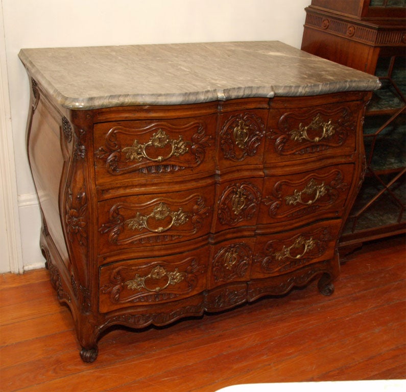 Period Regence Walnut Commode with sunflower motif and Bombe' (galbe) sides and serpentine and bombe' front. Pulls apear original as does the marble top.