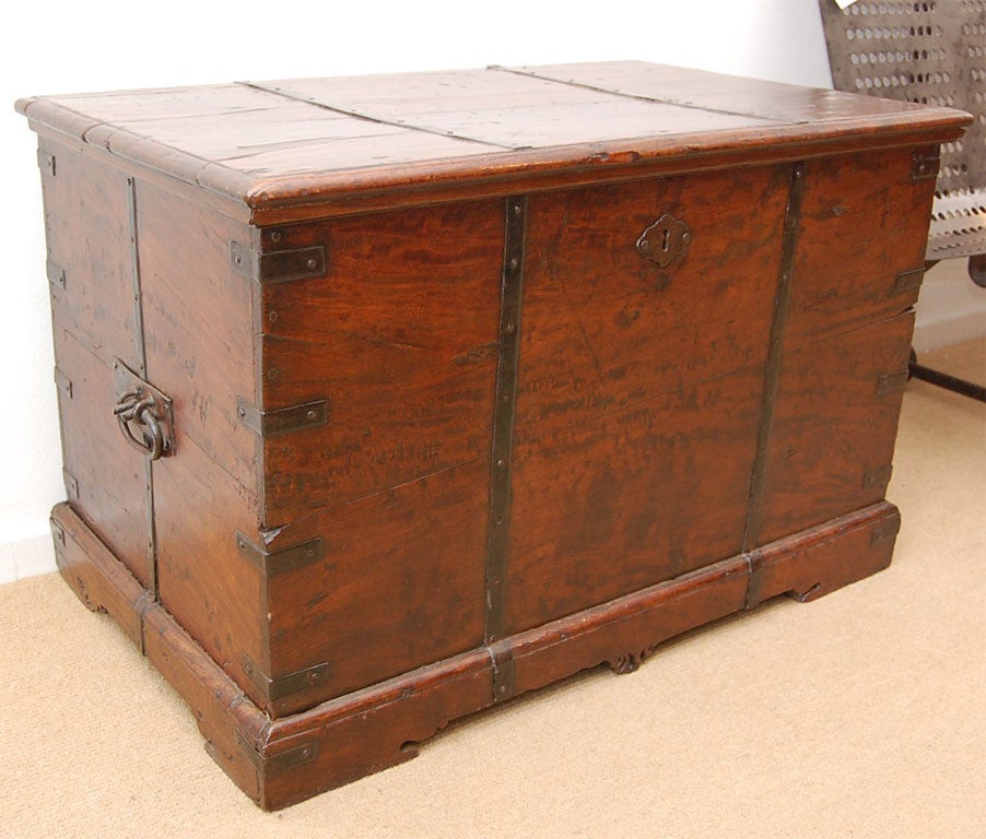 A 19th century Anglo-Indian teak tea chest with original iron banding, carrying handles and decorative bracket feet.