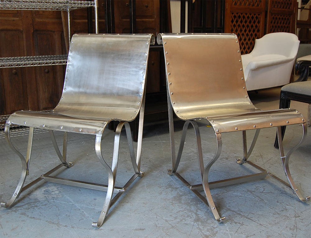 Handsome sleigh chair in polished nickel finish.  Sophisticated chair perfect in a modern or traditional setting.  This chair offers stylish lines and industrial rivet detailing.