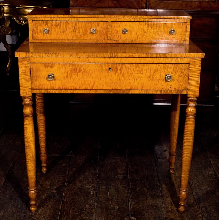 A vividly figured tiger maple 'step-back' stand; three drawers with original brass pulls.  A rare form usable as a hall, side or dressing table; its original intended use.
