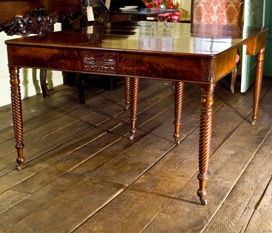 Salem, Massachusetts Classical Period Cuban Mahogany dining table with specimen 'cathedral grained' top, hand-carved foliate trimmed end and corner plaques; and twist legs ending in casters.  The corner and interior support legs are unobtrusive to