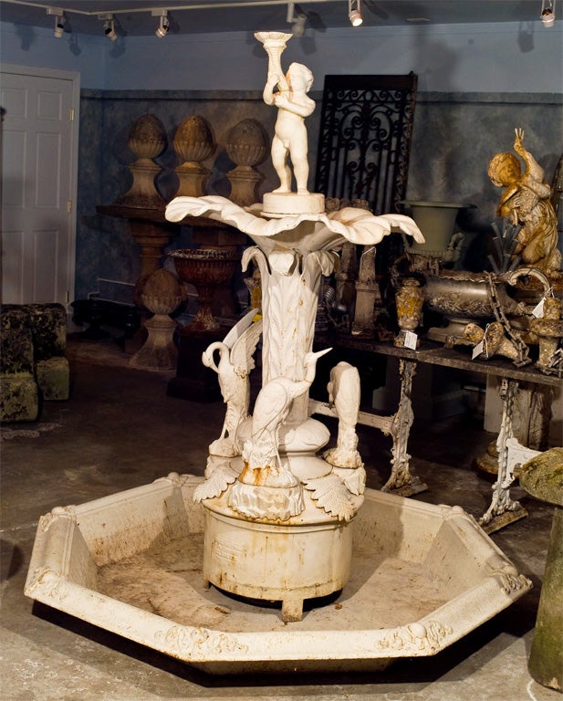 With a stunning octagonal cast iron pan, this magnificent fountain features three removable egrets, each in a different position on rockwood bases, a rising stiffleaf body, eight-petal bowl, and putto with cornucopia. Signed George Smith, Sun