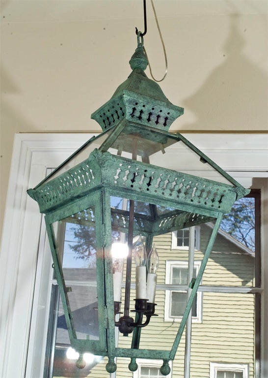 One of a pair of wonderfully-different copper gas lanterns with rare pierced top and glassed roof, fully restored and rewired with four 75 watt candle bulbs.  Surface overpainting done to even-out the patina.