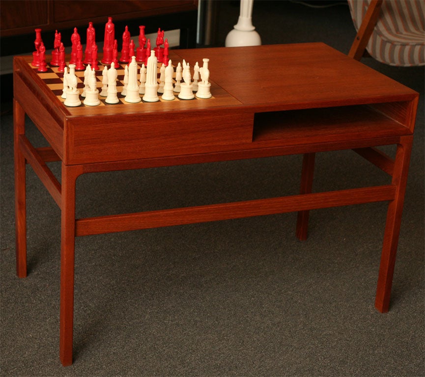 SOLD JULY 2010 Deftly designed with a game board that hides away this Danish Teak Game Table by Kurt Ostervig is swell.  Unique half sliding top that flips from teak to chess/checker board of inlayed rosewood and ash squares.  Underneath that