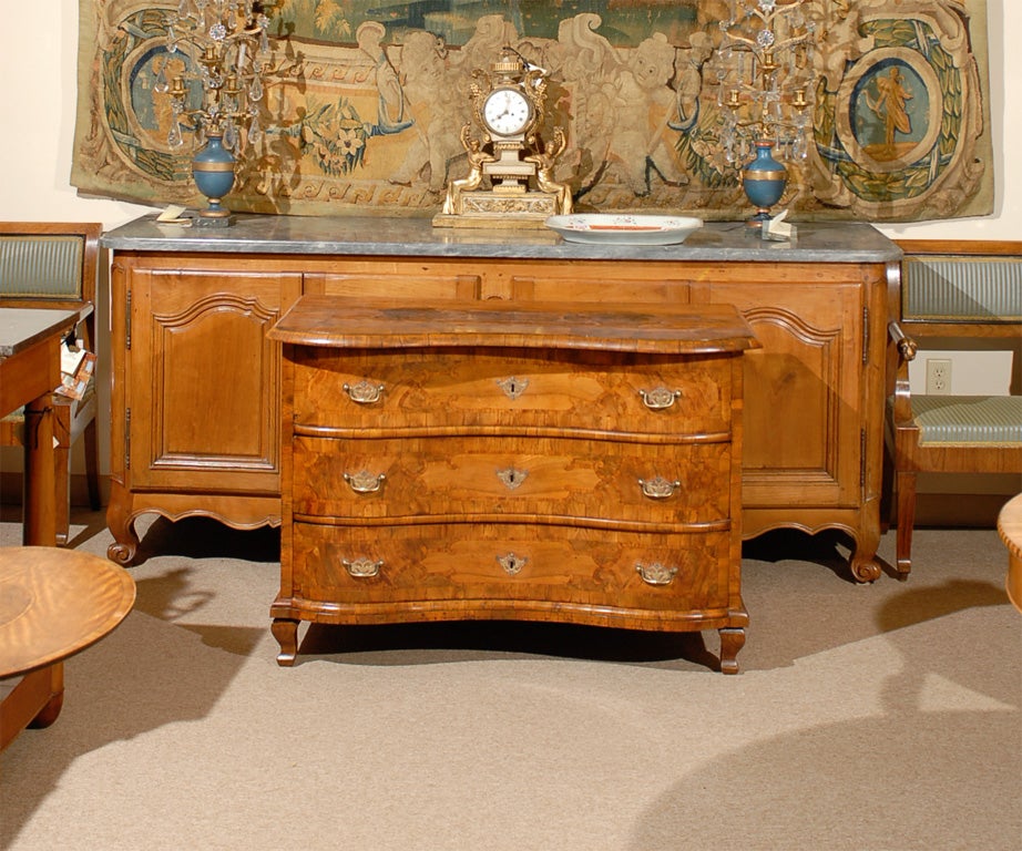 An Impressive serpentine inlaid walnut commode with three drawers and brass hardware. All resting on cabriole feet. The commode dating from the last quarter of the 18th century and Italian/ S. Germany in origin. <br />
<br />
For many more fine