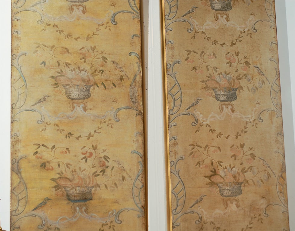 A pair of French 18th century hand-painted decorative panels with birds in foliage motifs. Each of this pair of French panels features a simple silhouette adorned with a bonnet top and rhythmically adorned with a delicate decor of foliage and birds.