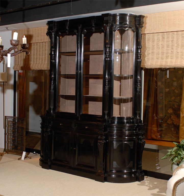 Very Large Ebonized Bibliotech with two doors above flanked by two curved glass doors with two cabinet doors below flanked by two curved cabinet doors.  Beautiful carving. Upper portion and drawers newly relined with taupe fabric.