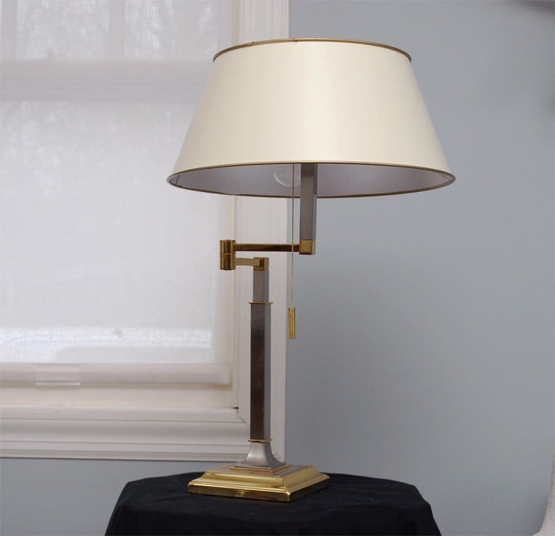 Three-light table lamp with adjustable arms, the whole in satin steel and polished brass; pull chain; ivory shade included