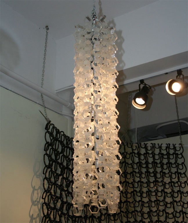 Frosted glass hexagonal chain links hook together creating a stunning chandelier. Sixteen bulbs illuminate this unusual light.