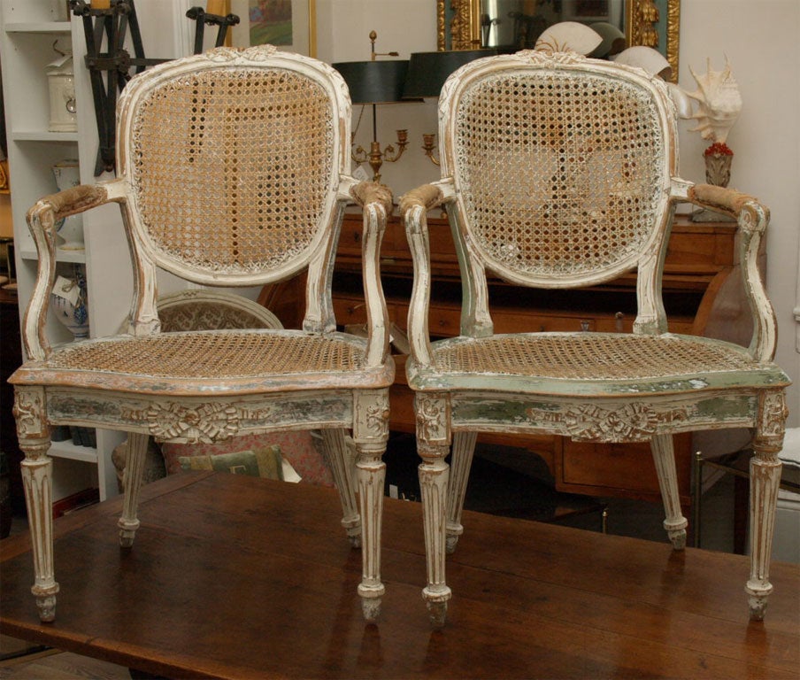 Painted White with Green highlights, cane seat and back and fluted legs.