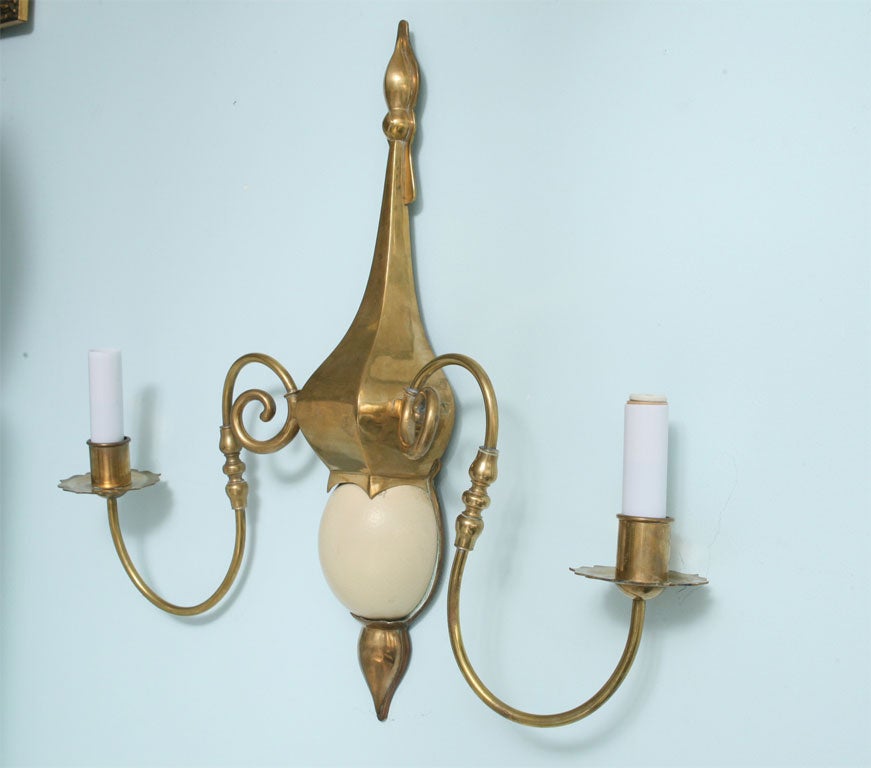 Pair of signed two-light Chapman sconces executed in brass with an composition ostrich egg inset into each sconce.Great scale and size.Adjustable arms.