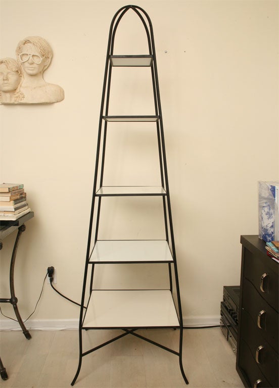 Five tier oblisk shape iron etagere with original milkglass shelves. Flaired legs.