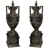 Pair of Black Terracotta Lidded Urns on Plinths