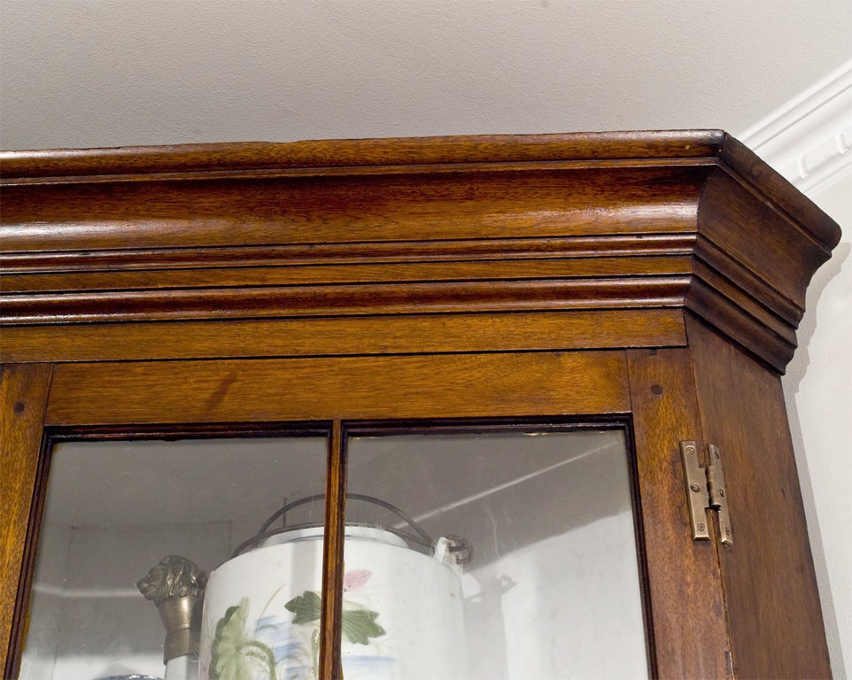 Beautiful Chippendale of the federal period. Solid walnut corner cabinet, dated 1840,  with 16 mullened individual pane doors atop a two solid-door cabinet standing on bracket feet.