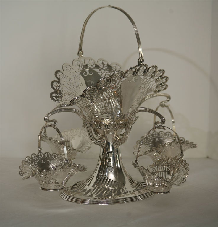 This elegant and versatile sterling silver centerpiece is made up of an oval footed center Stand, a large center basket and four matching hanging baskets. Retailed and marked 