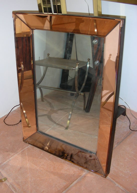 Two 1940s mirrors with pink mirror frame and metal corners; wood on back. Price indicated for two, but could be sold separately.