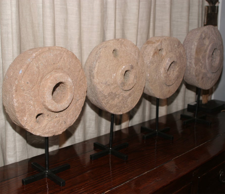 Grinding Stone Wheels on stands.  Pink/Gray stone with decorative carvings.  Sizes vary.  These are small, with diamters ranging 10 1/2