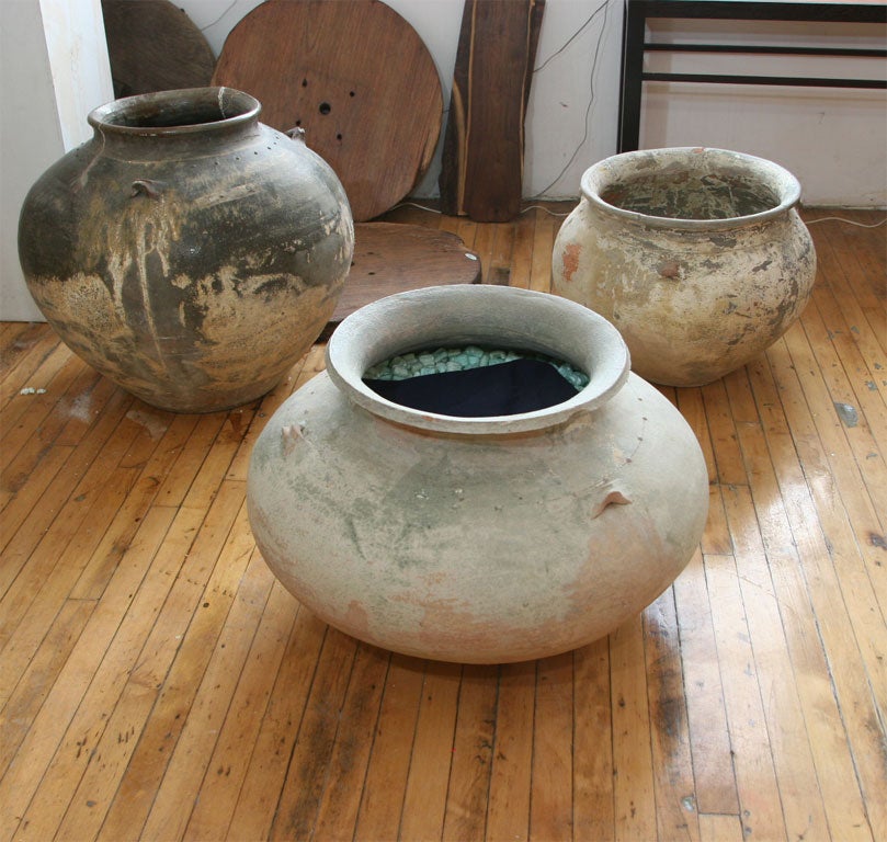 Wonderfully potted vessel with a rustic textured glaze in green and grey hues with rust highlights.