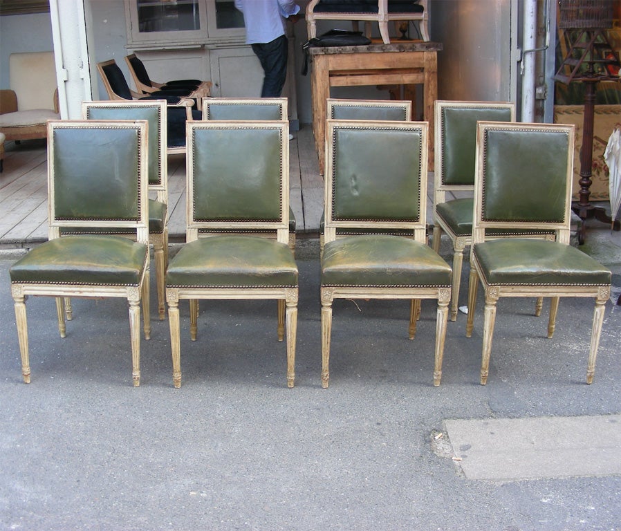 Eight 1940s Louis XVI style chairs in cream patina and green leather upholstery, in the style of Jansen.