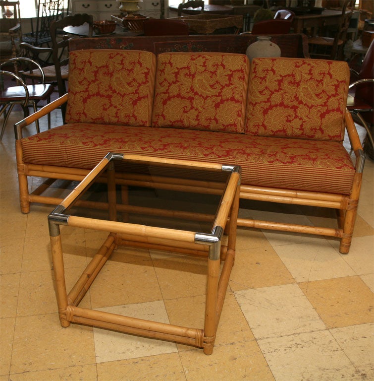 Stylish and comfortable Ficks Reed Bamboo with chrome accented Sofa.  Great as patio, porch or family room sofa covered in pretty red/chartreuse paisley and stripe fabric.  Table is $450.00.  24 x 24 x 20h.  Sold separately.