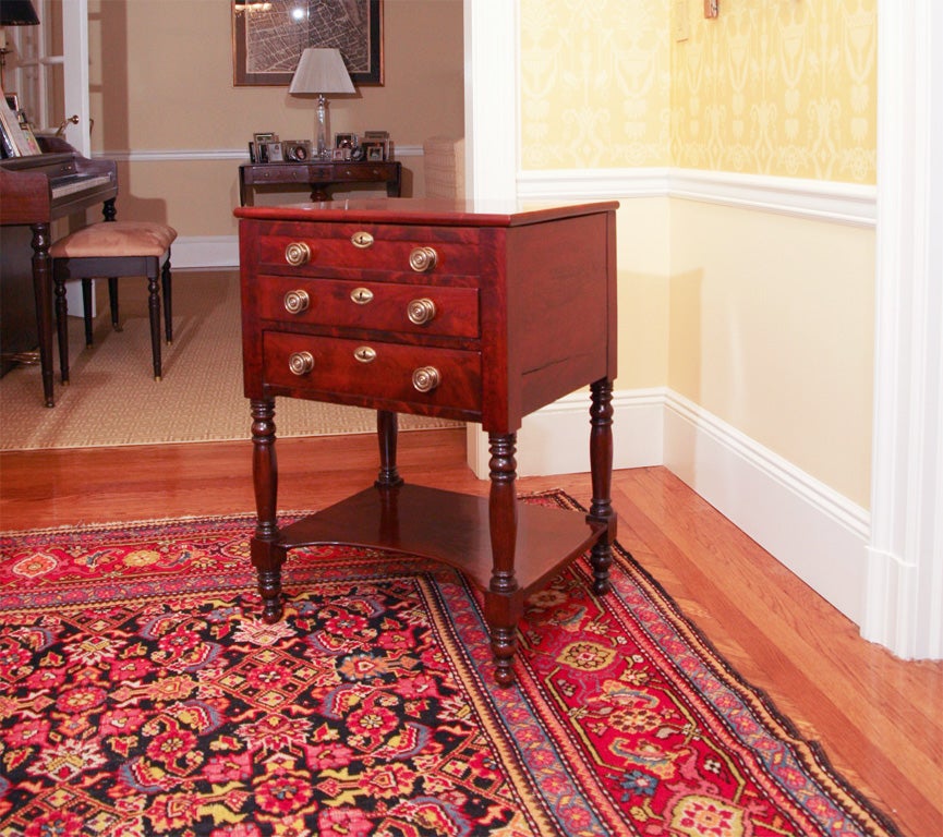 An English mahogany work stand with two drawers, turned legs, lower shelf and top opening to reveal work surface and pen and ink compartment.