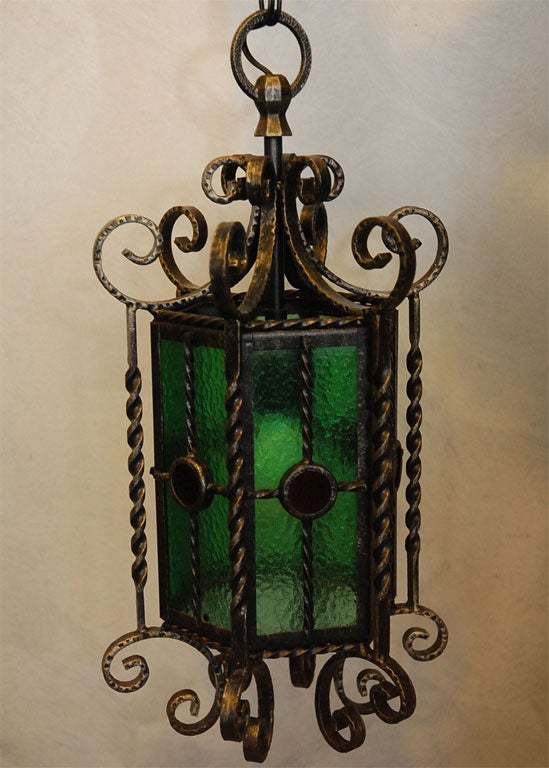 This pair of lanterns are most likely French and from the 1930's. Each lantern has six panels having; central medallions, glass panels and a collection of hand beaten curved, twisted, formed and hand decorated elements. The finish is coal black and