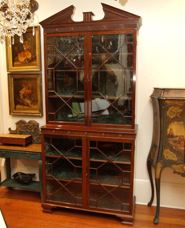 George III mahogany and original glazed bookcase with glazing on bottom and top. Great form with broken arch pediment and carved frieze