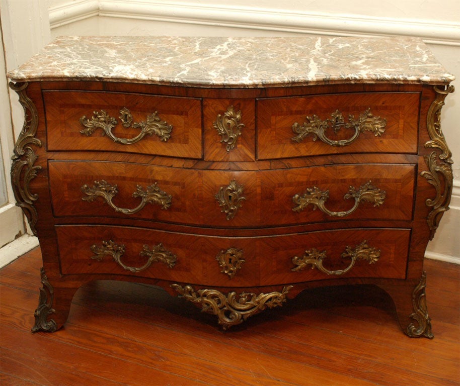 Period Paris Regence Commode with original ormolu and marble top. Kingwood,rosewood and ebony marquetry.

C'est magnifique.