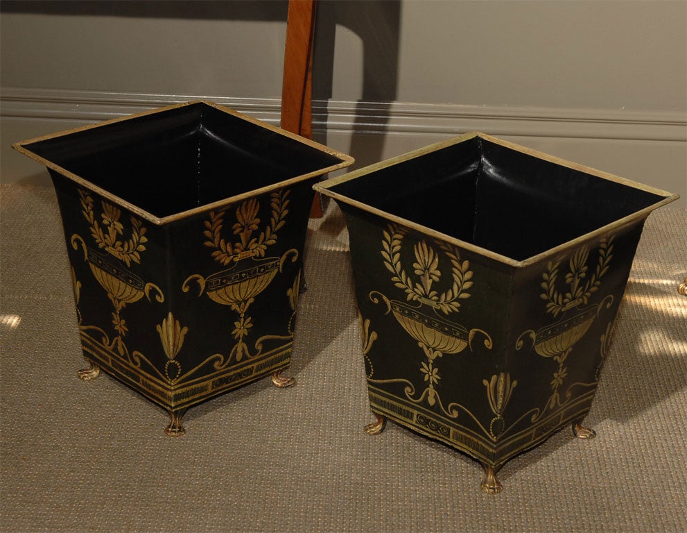 Each square tapering body decorated with a center urn and laurel leaf wreath on all four sides; exterior background painted dark green with an interior of black; the whole raised on petit pieds.