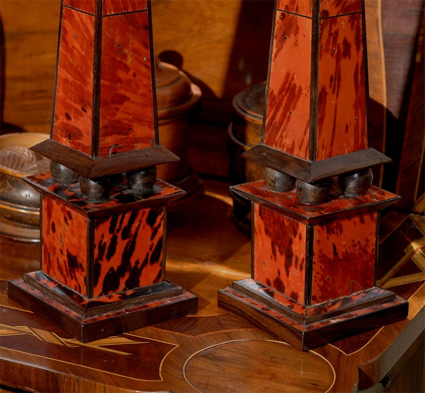 Each of tall, narrow, tapering four sided form; surmounted by a pyramidal top; the whole fabricated of red tortoiseshell with ebonized wood accents.