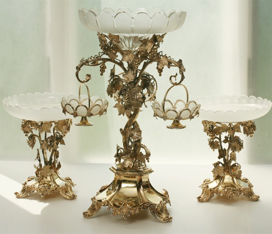 Magnificent three-piece French silver plate vermeil centerpiece/garniture with grapevine and leaf motif. Centerpiece features three detachable hanging baskets for flowers, fruit or sweets with hand blown crystal scalloped edged bowls with frosted