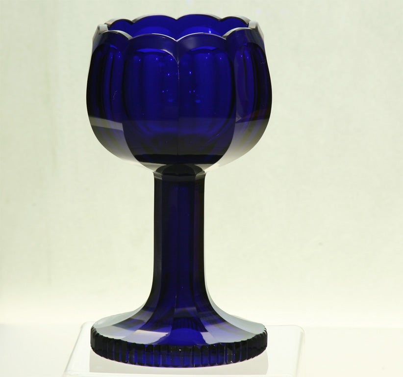 Featuring a pair of Moser hand blown, rich, deep cobalt blue crystal tall chalices with panel cut stems and finely cut bases. The bowls are also panel cut and the top rims are cut with a petal motif. Heavy and thick blanks maintaining a very