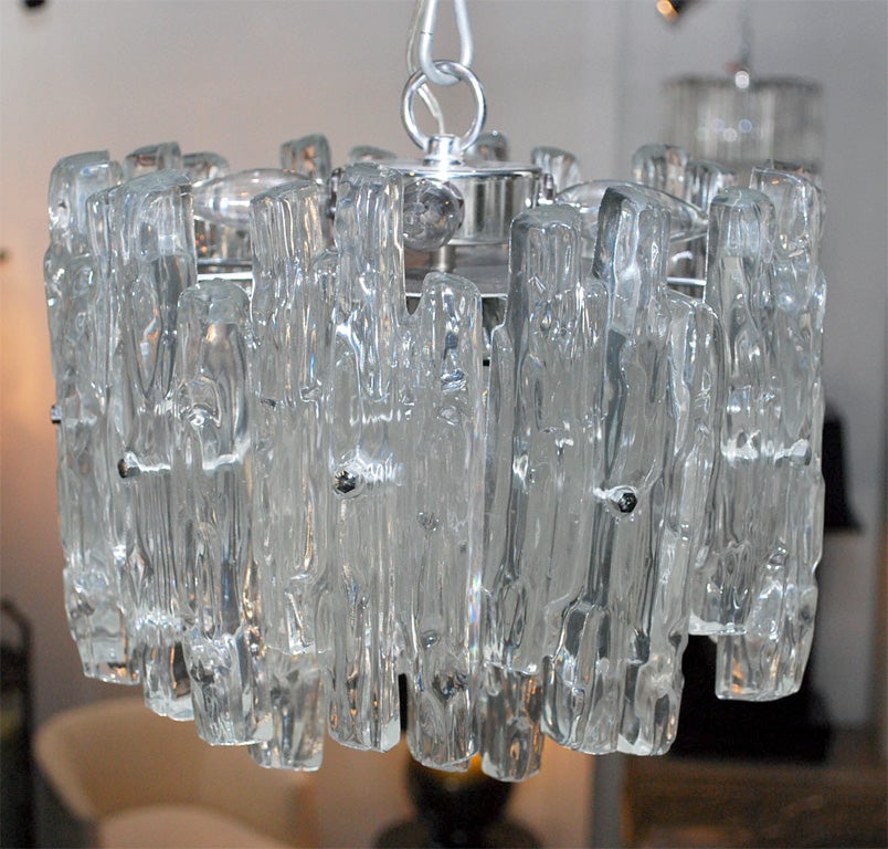 Sculptured two tiered lucite icicle chandelier supported by a chrome frame, with seven light sources.