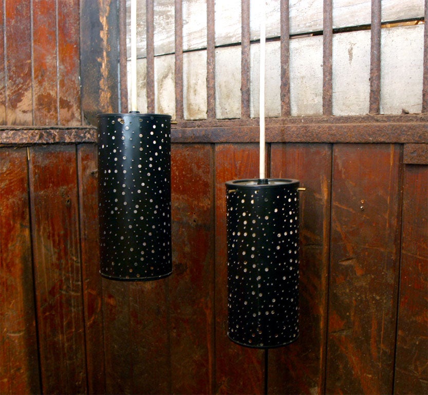 Pair of pierced, black painted metal cylindrical hanging lights.
