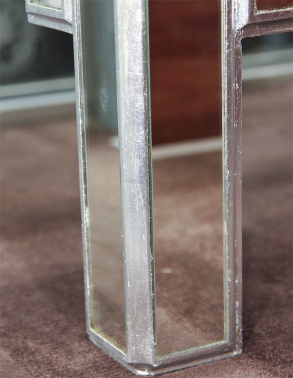 Pair of gorgeous Art  Deco revival occasional tables with Skyscraper design in the manner of James Mont. These stylized tables feature a silver leaf finish with inset mirrored tops and mirrored panels throughout. They would make outstanding