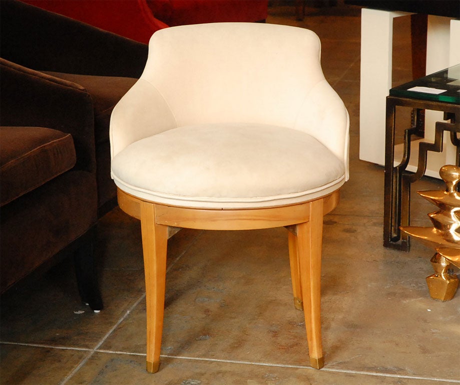 Elegant swivel vanity stool with brass trimmed sabre legs and  brass sabots.  Low backed seat is freshly upholstered in beige ultrasuede.