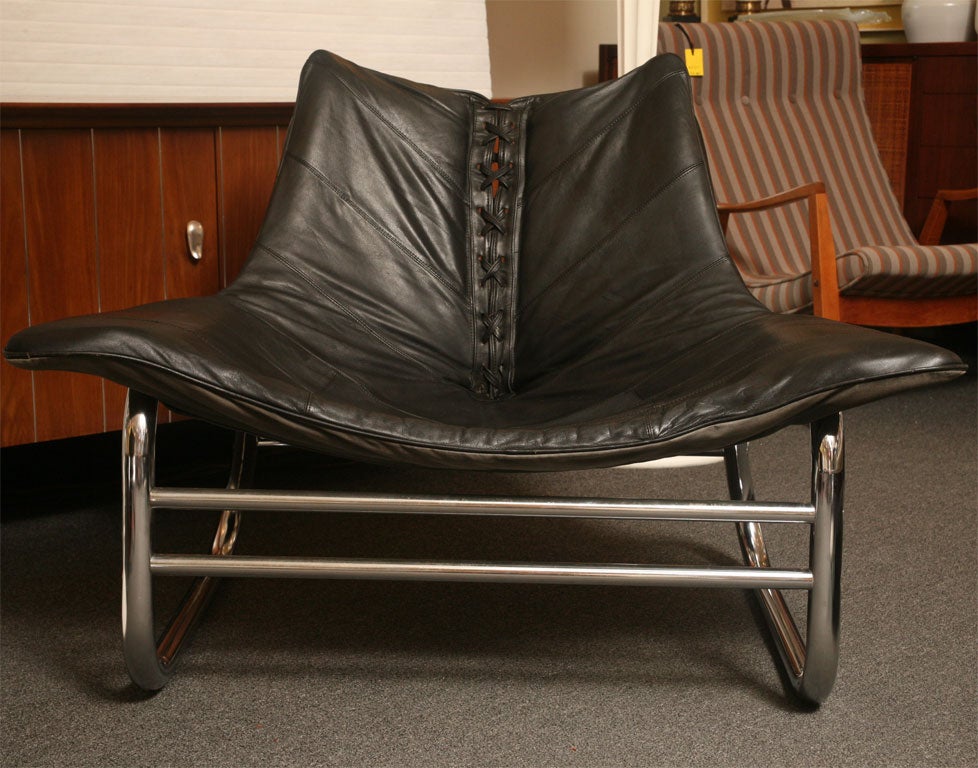 REDUCED FROM $4250....Leather sling chairs with attitude. This extraordinary pair of black leather and fat tubular chrome are quite a statement and quite comfortable with their body hugging shape and wide wing like arms. Beautifully stitched soft