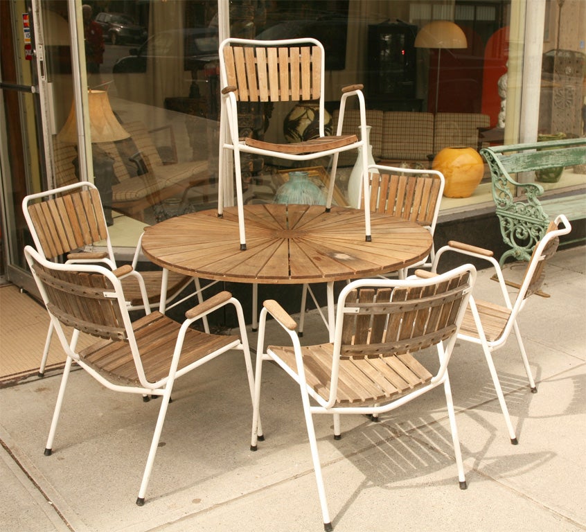 Round teakwood table with six matching chairs for the garden or porch.  Can be used outside. Chairs comfortably curved,  table legs fold and chairs easily stackable.
